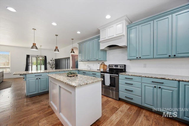 kitchen featuring a peninsula, electric range, blue cabinetry, a center island, and decorative light fixtures