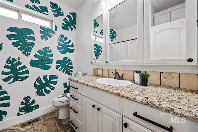 full bathroom featuring toilet, vanity, and visible vents