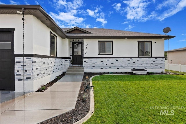 view of front facade featuring a garage, a front lawn, and stucco siding