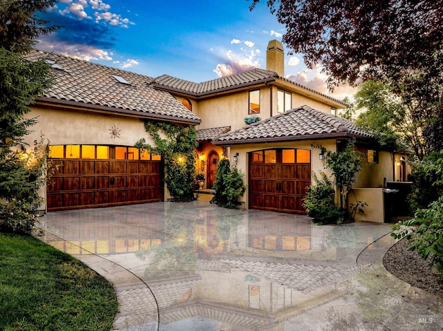 mediterranean / spanish home featuring a garage