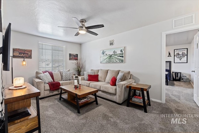 living room featuring ceiling fan, a textured ceiling, and carpet flooring