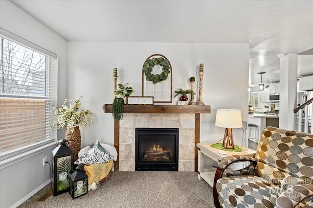 carpeted living room featuring a tiled fireplace