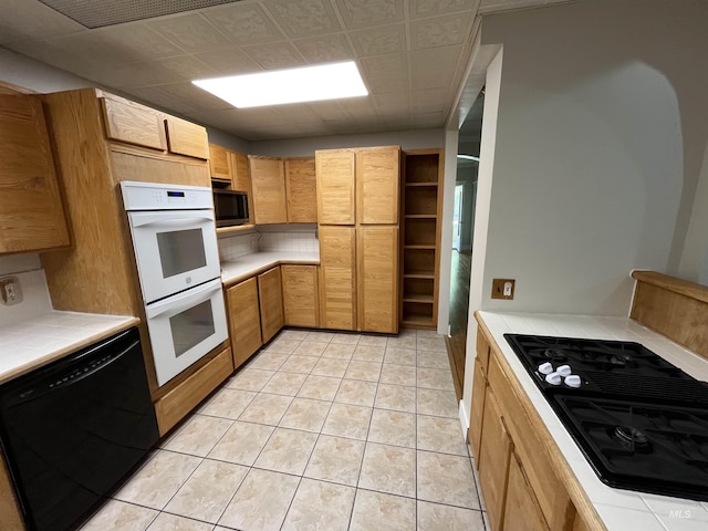 909 E 6th, Moscow, ID 83843 - kitchen featuring black appliances, tile counters, and light tile patterned floors