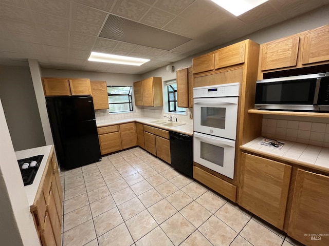 909 E 6th, Moscow, ID 83843 - kitchen featuring black appliances, a sink, tile counters, tasteful backsplash, and light tile patterned floors