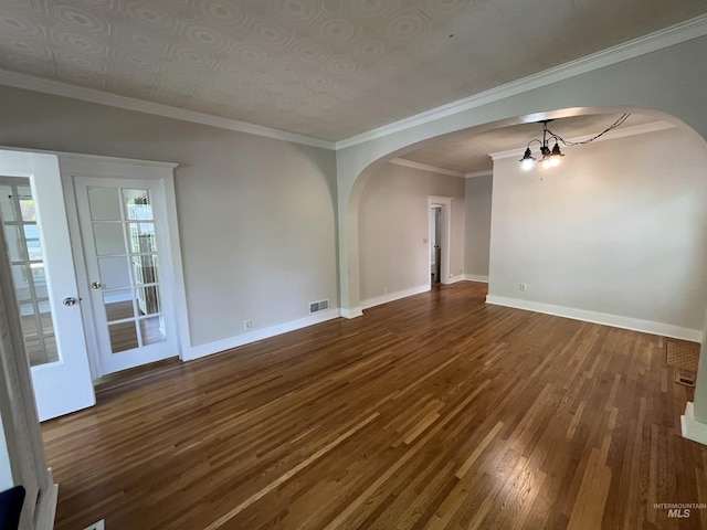 909 E 6th, Moscow, ID 83843 - unfurnished living room with arched walkways, a chandelier, dark wood-style floors, baseboards, and crown molding