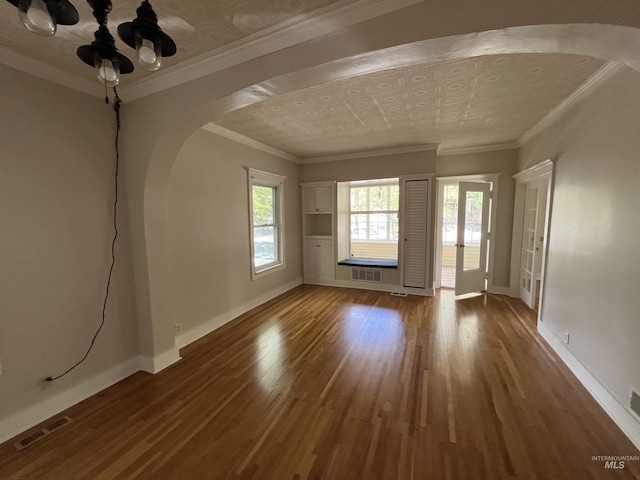 909 E 6th, Moscow, ID 83843 - empty room featuring arched walkways, wood finished floors, baseboards, and crown molding