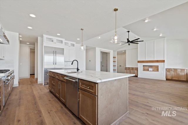 kitchen featuring light wood-style floors, a sink, white cabinets, and stainless steel appliances