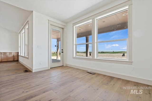 doorway featuring baseboards, visible vents, and light wood-style flooring