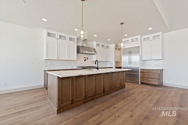 kitchen with built in refrigerator, decorative backsplash, recessed lighting, and extractor fan