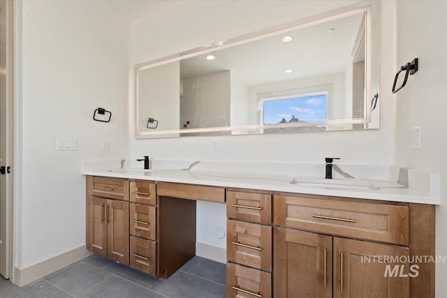 bathroom with a sink, baseboards, tile patterned flooring, and double vanity
