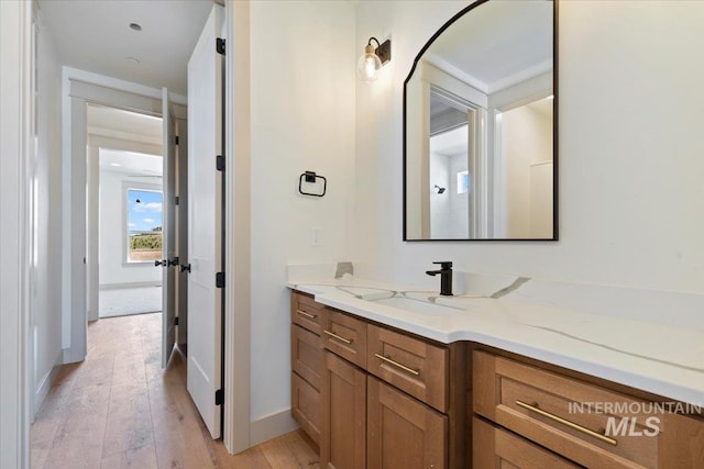 bathroom featuring baseboards, hardwood / wood-style flooring, and vanity