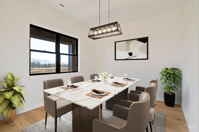dining area featuring baseboards, visible vents, and light wood-type flooring