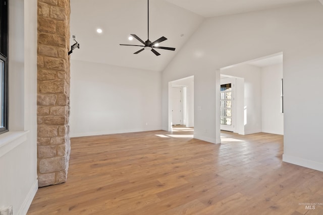 empty room featuring high vaulted ceiling, light wood-type flooring, and ceiling fan