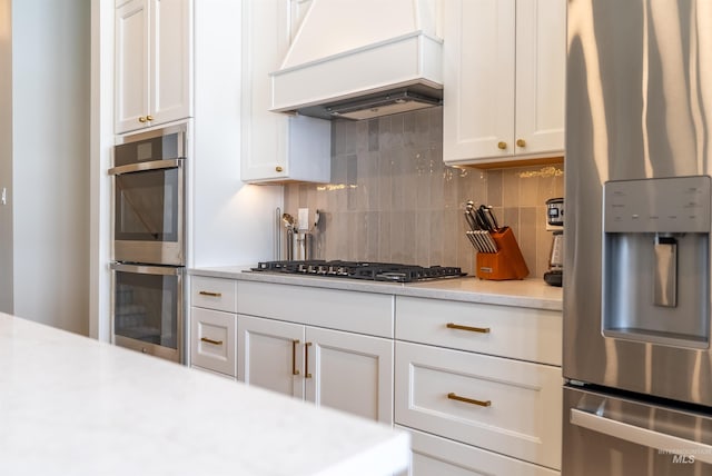 kitchen featuring premium range hood, stainless steel appliances, backsplash, and light countertops