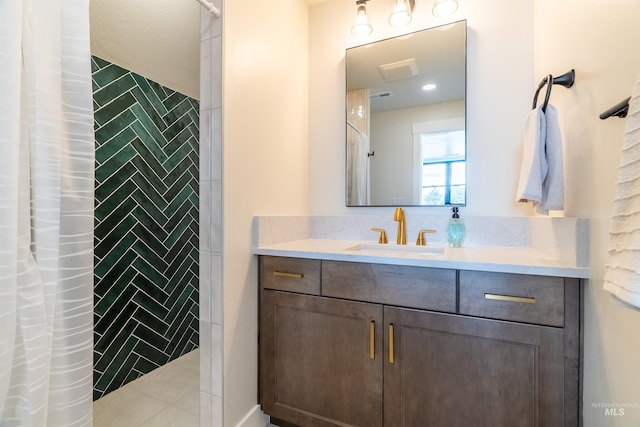 bathroom featuring vanity, visible vents, and tiled shower