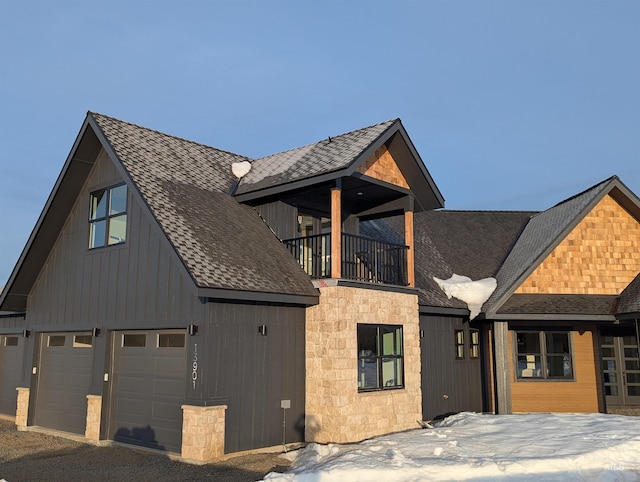 view of front of home featuring a balcony, a garage, and a shingled roof