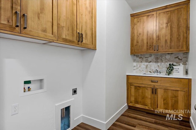 washroom featuring electric dryer hookup, dark wood-style floors, baseboards, hookup for a washing machine, and cabinet space