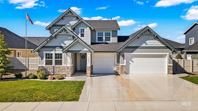craftsman inspired home with fence, an attached garage, stone siding, a front yard, and concrete driveway