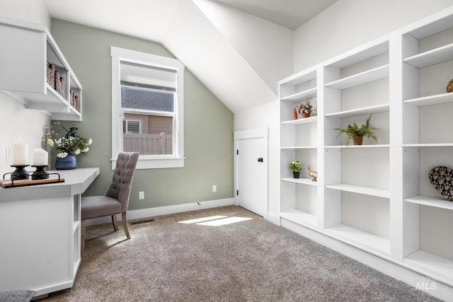 carpeted home office featuring baseboards and vaulted ceiling