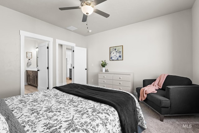 bedroom with connected bathroom, a ceiling fan, visible vents, and light carpet