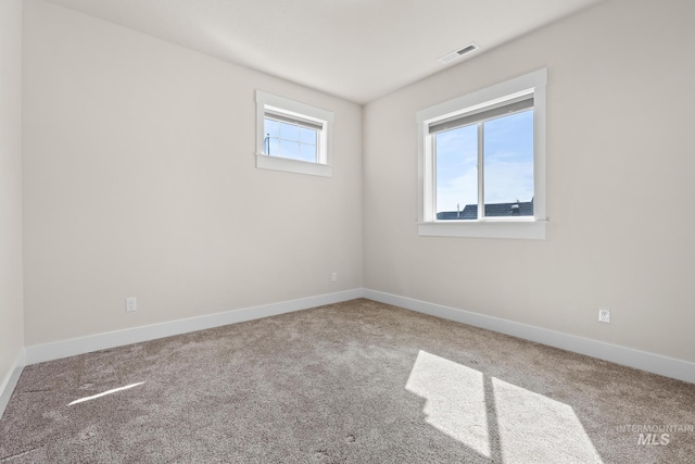 empty room with baseboards, carpet flooring, and visible vents