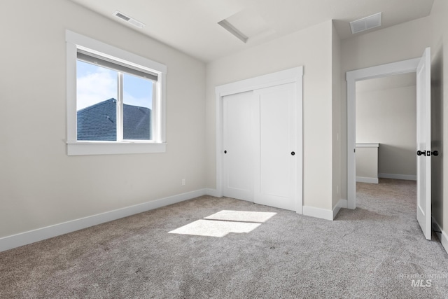 unfurnished bedroom featuring carpet flooring, baseboards, visible vents, and a closet