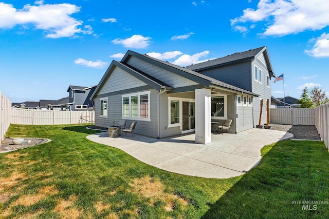 back of property with a patio, a fenced backyard, and a yard