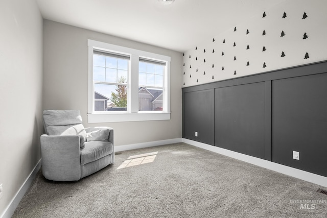living area with baseboards, visible vents, and light carpet