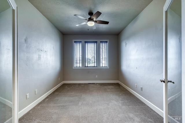 carpeted empty room featuring ceiling fan and a textured ceiling