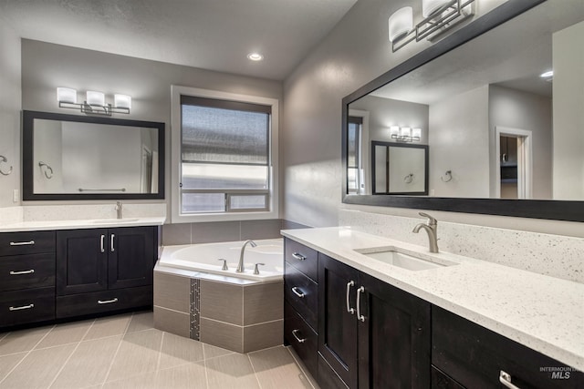 bathroom featuring tiled bath, tile patterned flooring, and vanity