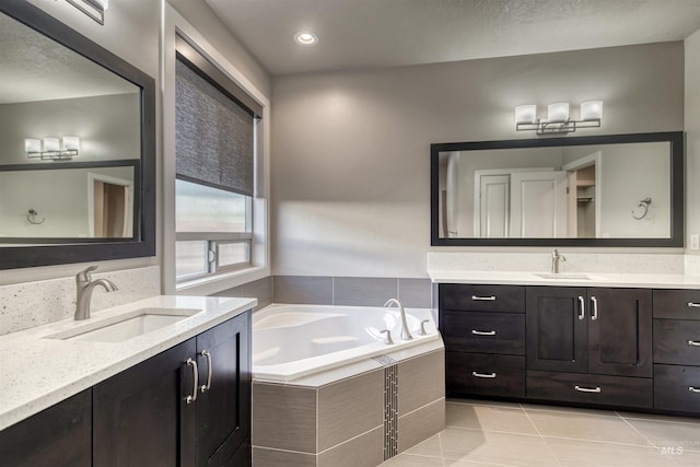 bathroom with tile patterned floors, vanity, and a relaxing tiled tub