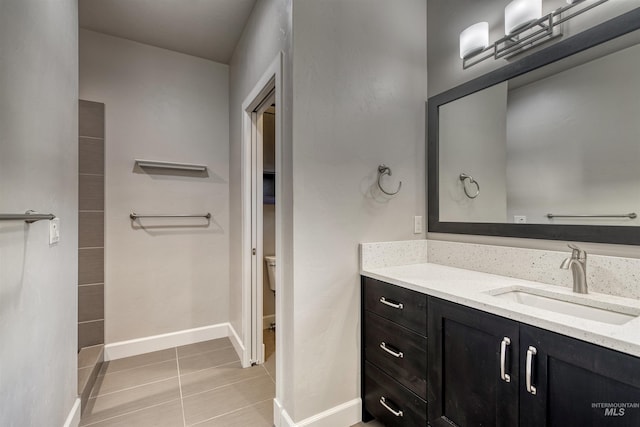 bathroom with tile patterned flooring, vanity, and toilet