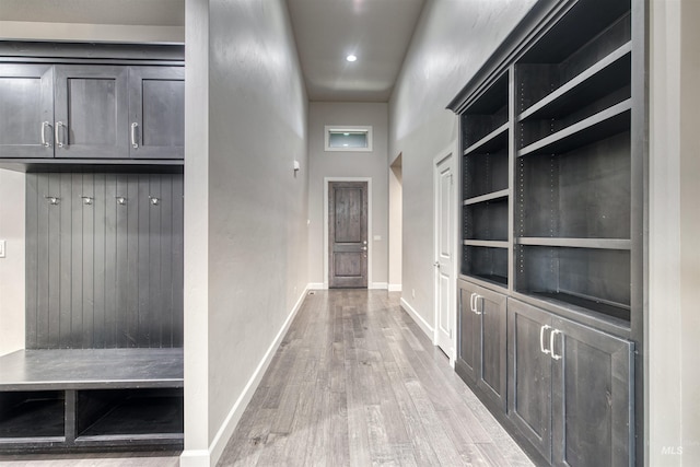 mudroom featuring a towering ceiling and light hardwood / wood-style flooring