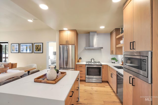 kitchen featuring light brown cabinets, open shelves, a sink, appliances with stainless steel finishes, and wall chimney exhaust hood