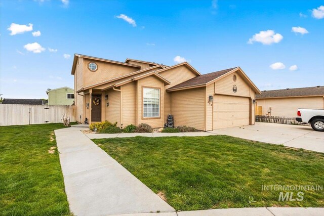 408 Tanoak Cir, Nampa, ID 83686 - view of front facade with a front lawn, an attached garage, concrete driveway, and fence