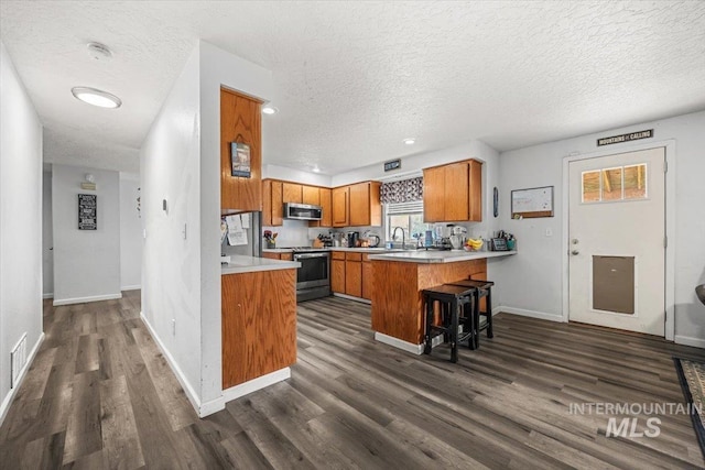 408 Tanoak Cir, Nampa, ID 83686 - kitchen featuring a sink, brown cabinets, stainless steel appliances, light countertops, and a peninsula