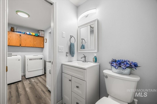 408 Tanoak Cir, Nampa, ID 83686 - half bath featuring separate washer and dryer, wood finished floors, vanity, and toilet