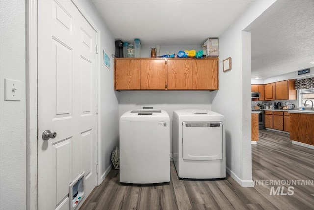 408 Tanoak Cir, Nampa, ID 83686 - laundry room featuring wood finished floors, a textured ceiling, cabinet space, washing machine and dryer, and baseboards
