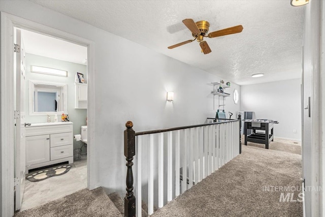 408 Tanoak Cir, Nampa, ID 83686 - hall with light carpet, a sink, a textured ceiling, and an upstairs landing