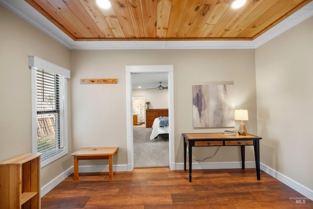 hallway with crown molding, wood finished floors, wooden ceiling, and baseboards