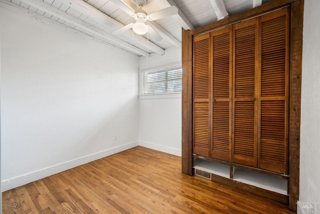 unfurnished bedroom with baseboards, wood finished floors, a closet, wooden ceiling, and a ceiling fan