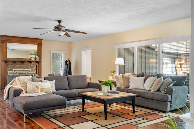 living room featuring a ceiling fan, wood finished floors, and a textured ceiling