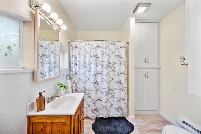 bathroom featuring baseboard heating, vanity, toilet, and a shower with curtain