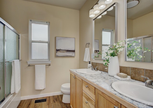 bathroom with vanity, wood-type flooring, a shower with door, and toilet