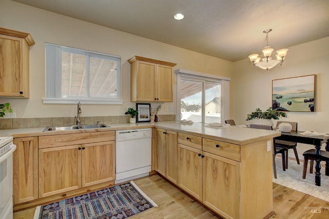 kitchen with sink, hanging light fixtures, light brown cabinets, kitchen peninsula, and white appliances