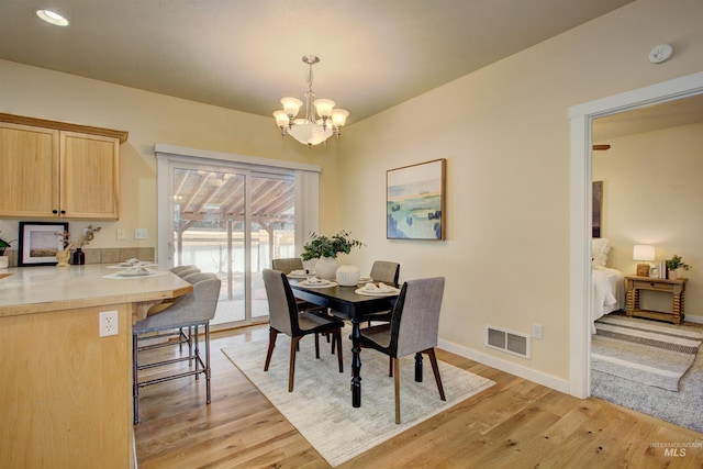 dining space with a chandelier and light wood-type flooring