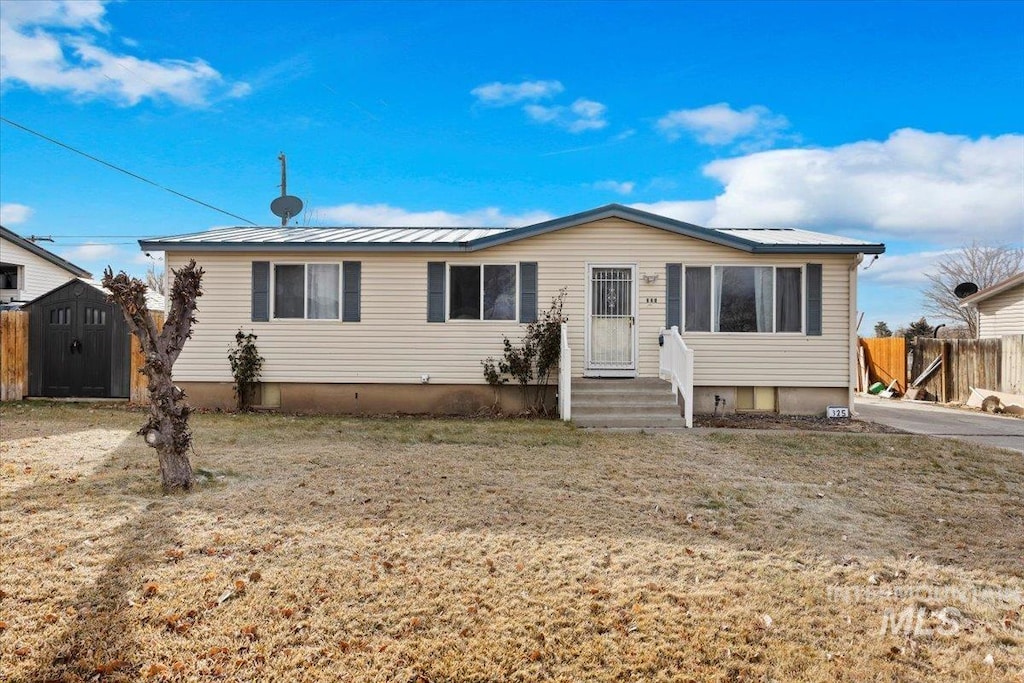 view of front of property with a front lawn and a storage shed