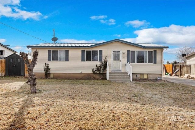 view of front of property with a front lawn and a storage shed