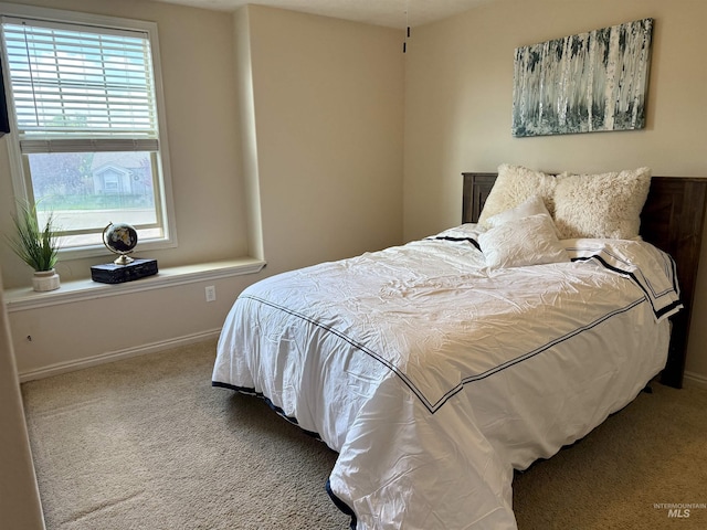 bedroom featuring carpet floors and baseboards