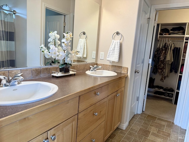 full bath with a spacious closet, double vanity, and a shower with shower curtain